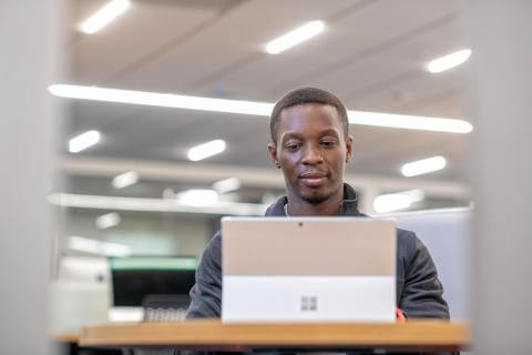 Man using a laptop in and smiling